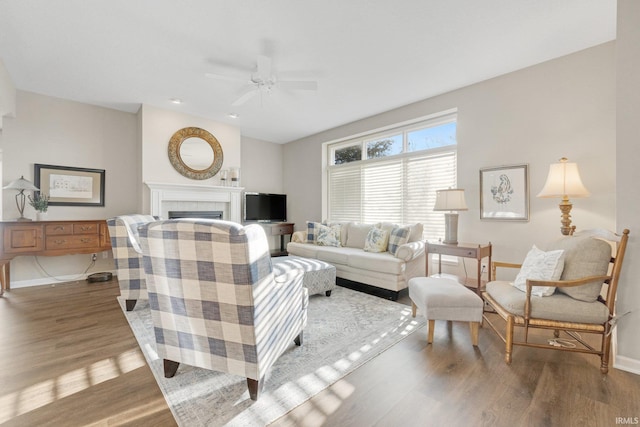 living room featuring hardwood / wood-style floors, a fireplace, and ceiling fan