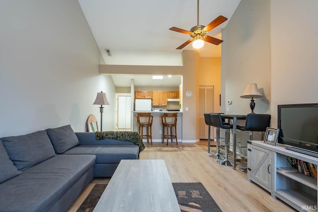 living room with vaulted ceiling, light hardwood / wood-style floors, and ceiling fan