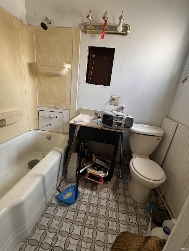 bathroom featuring vanity, a tub, and toilet