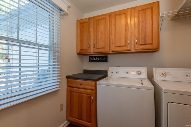 laundry area with separate washer and dryer and cabinets