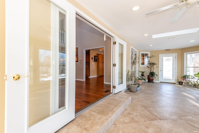 entrance foyer featuring ceiling fan and a skylight