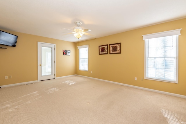 spare room featuring light carpet and ceiling fan