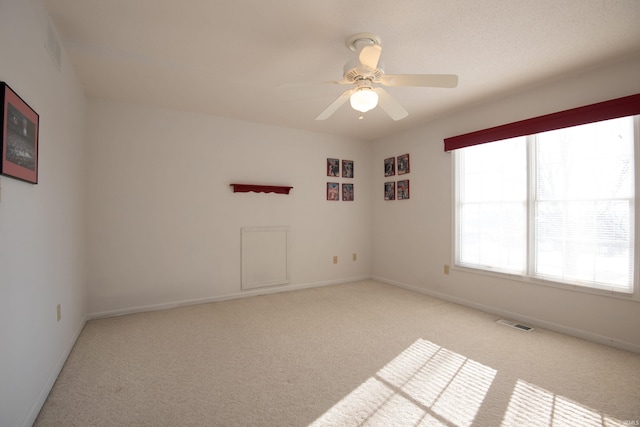 unfurnished room with light colored carpet and ceiling fan