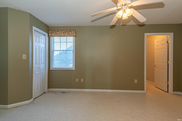 unfurnished bedroom featuring light colored carpet, ceiling fan, and a closet