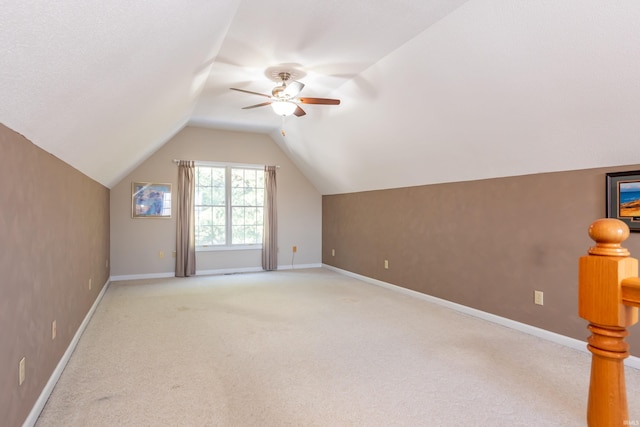 additional living space featuring ceiling fan, lofted ceiling, and light carpet