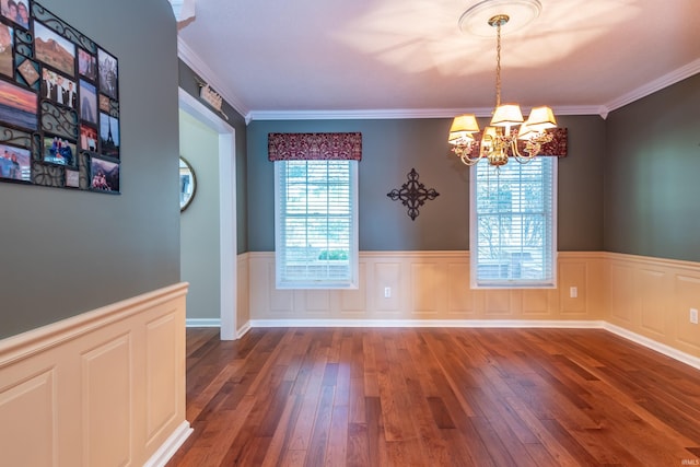 spare room featuring crown molding, dark hardwood / wood-style floors, and a chandelier