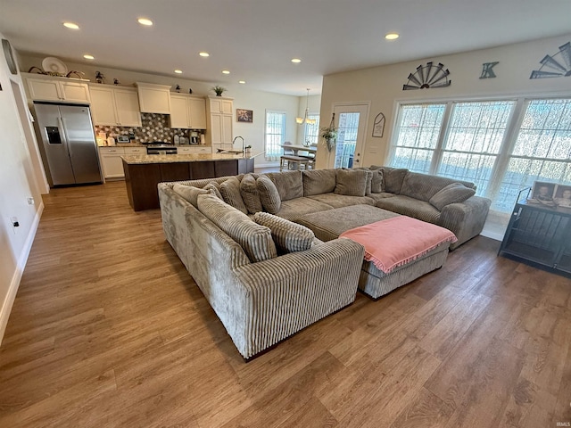 living room with sink and light wood-type flooring