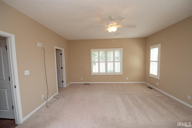 carpeted spare room featuring ceiling fan