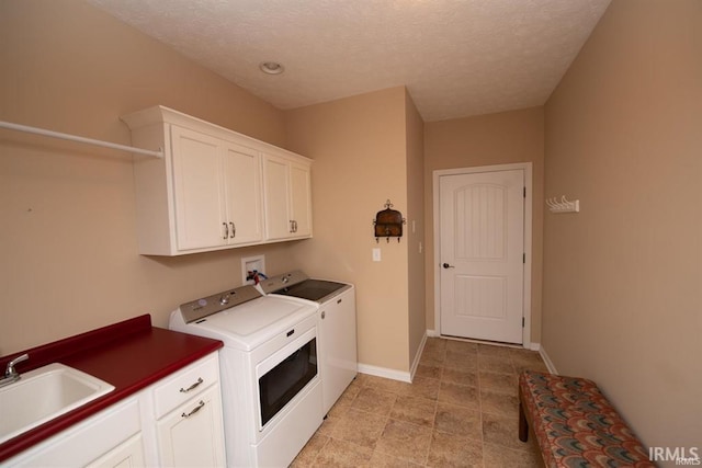 washroom featuring separate washer and dryer, sink, cabinets, and a textured ceiling