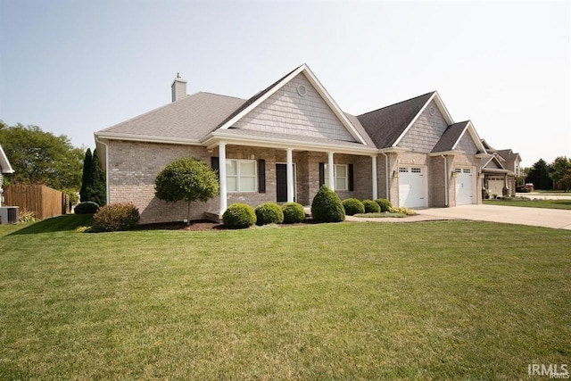 view of front of home featuring a garage, a front yard, and central air condition unit