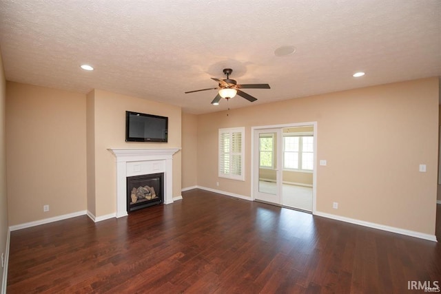 unfurnished living room featuring ceiling fan, a textured ceiling, and dark hardwood / wood-style flooring