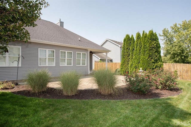 view of side of property featuring a yard and a patio