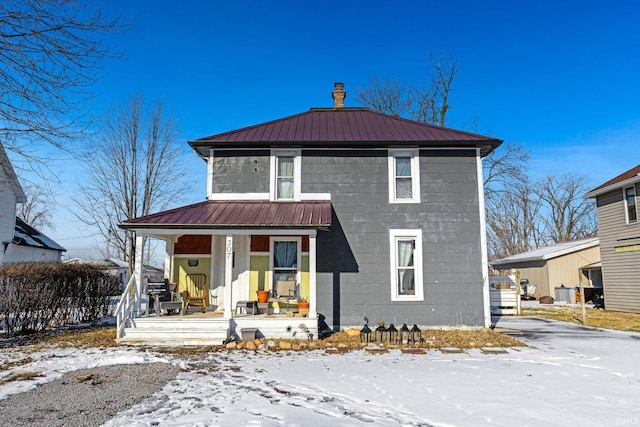 snow covered property featuring covered porch