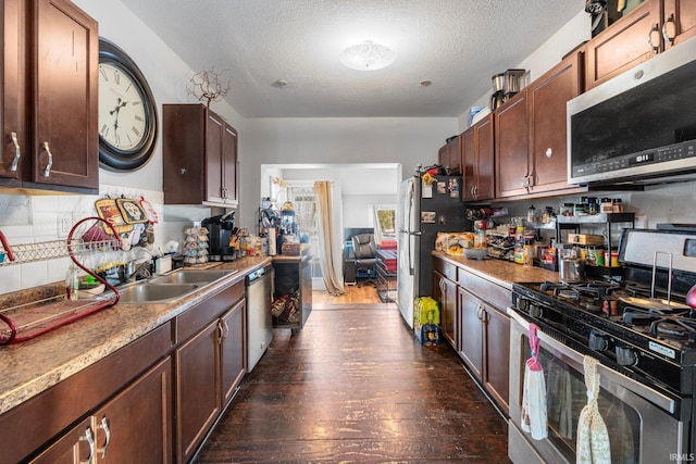 kitchen featuring tasteful backsplash, sink, stainless steel appliances, dark wood-type flooring, and a textured ceiling