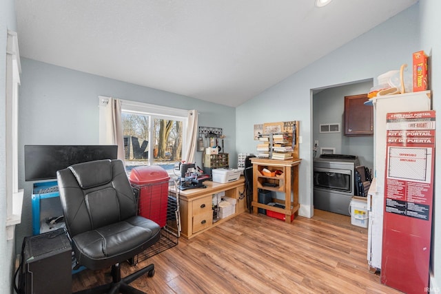 office featuring washer / dryer, vaulted ceiling, and light wood-type flooring