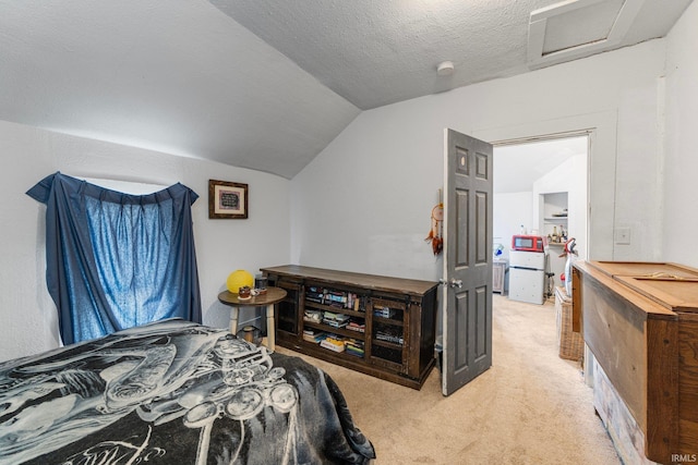 carpeted bedroom featuring vaulted ceiling and a textured ceiling