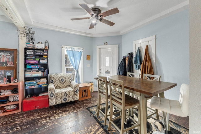 dining area featuring dark hardwood / wood-style floors, ceiling fan, and a tray ceiling