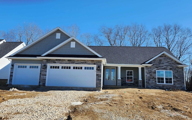 craftsman-style house featuring a garage, covered porch, and french doors