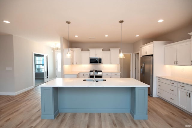 kitchen with pendant lighting, white cabinetry, an island with sink, and appliances with stainless steel finishes