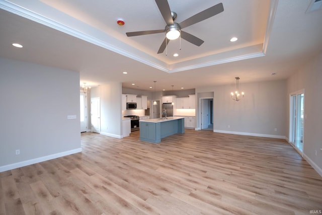 unfurnished living room with ceiling fan with notable chandelier, sink, ornamental molding, a raised ceiling, and light wood-type flooring