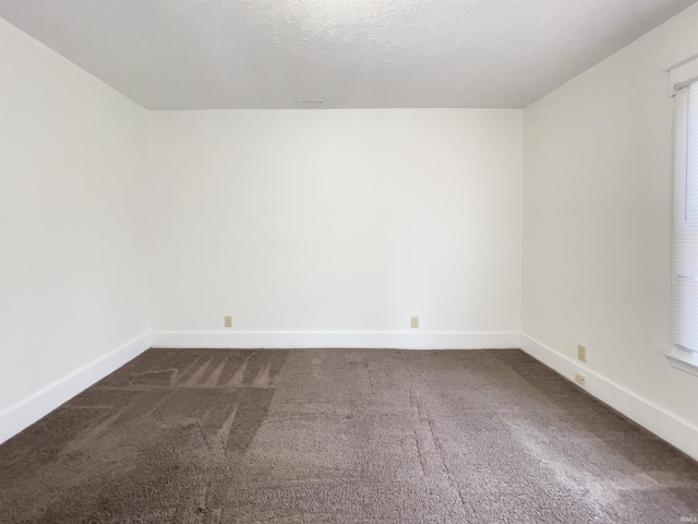 carpeted spare room featuring a textured ceiling