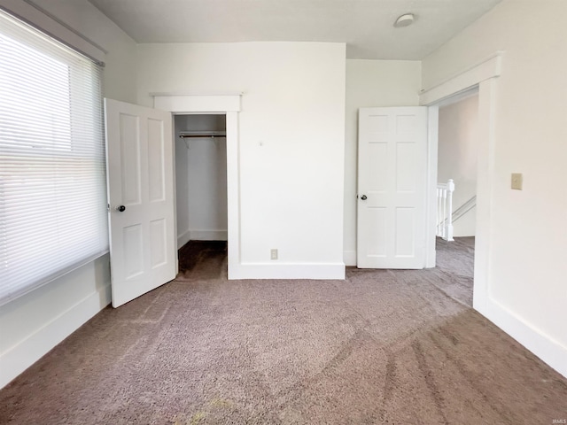 unfurnished bedroom featuring carpet and a closet