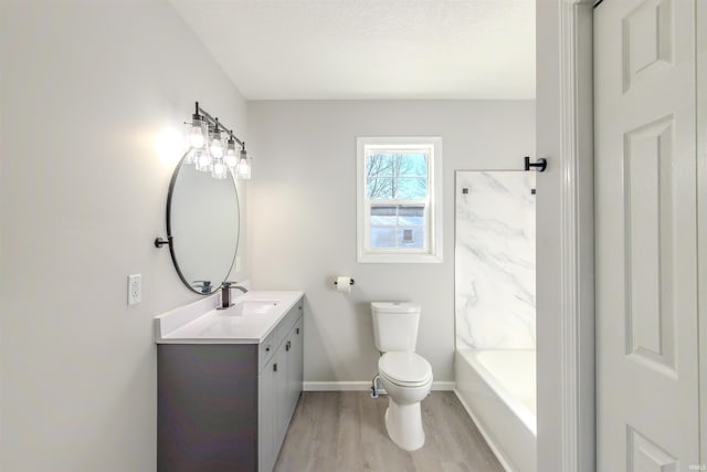 bathroom with vanity, toilet, hardwood / wood-style floors, and a textured ceiling