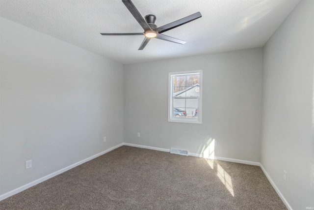 carpeted empty room featuring ceiling fan and a textured ceiling