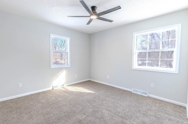 carpeted empty room with a textured ceiling and ceiling fan