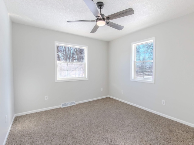 spare room featuring ceiling fan, carpet floors, and a textured ceiling