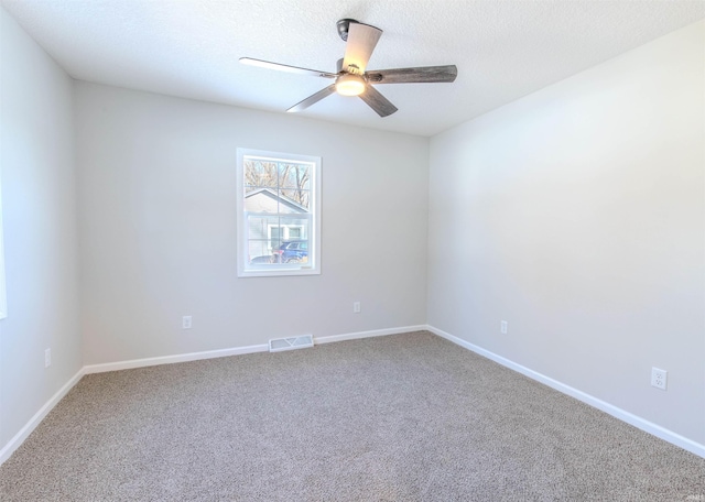 spare room with a textured ceiling, carpet floors, and ceiling fan