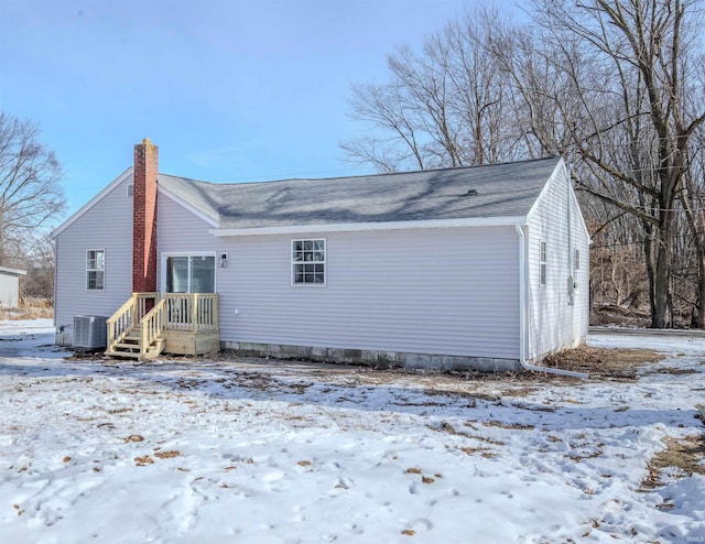 snow covered house with central AC