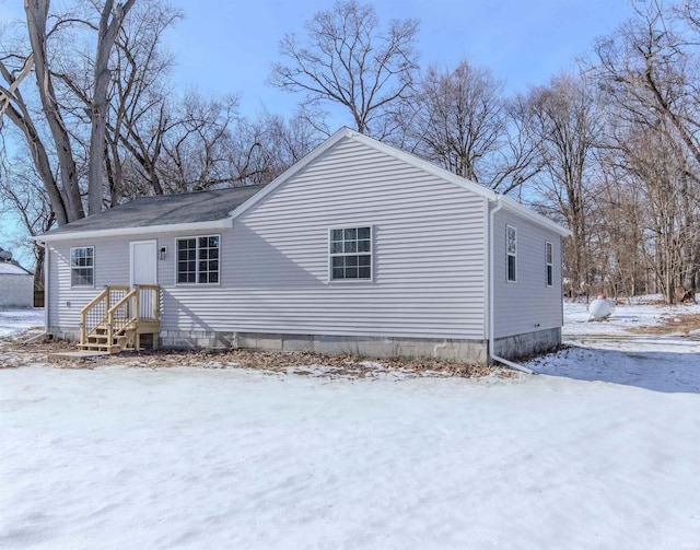 view of snow covered back of property