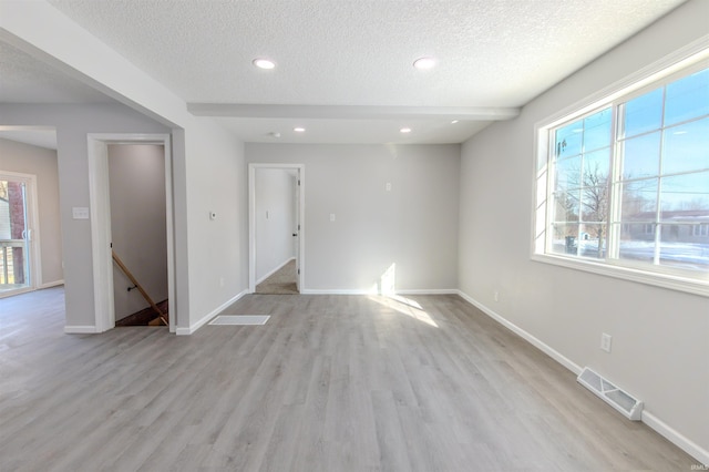 empty room featuring light hardwood / wood-style floors and a textured ceiling