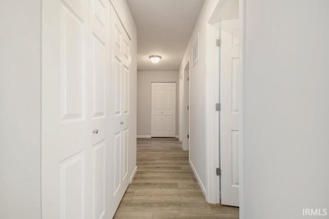 corridor with light hardwood / wood-style floors