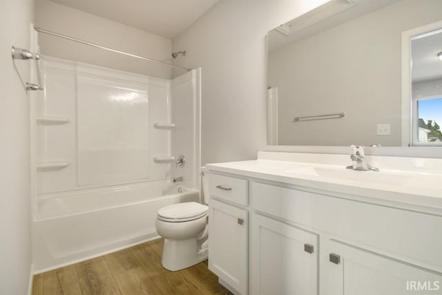 full bathroom featuring hardwood / wood-style flooring, shower / bathtub combination, vanity, and toilet