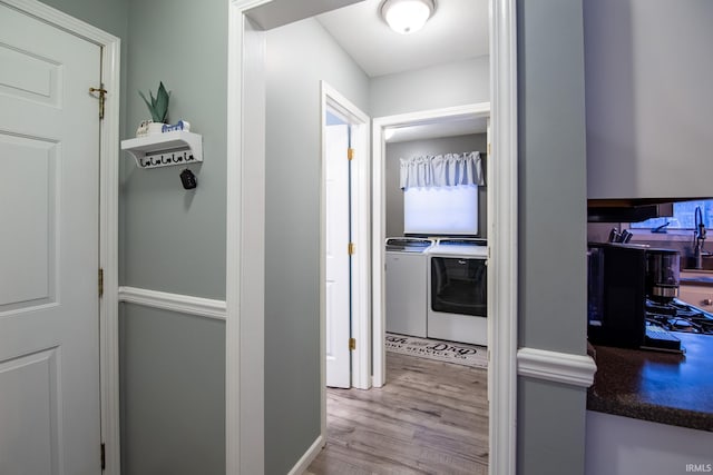 corridor featuring light wood-type flooring and independent washer and dryer