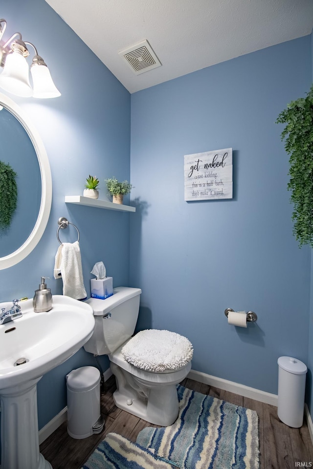 bathroom featuring sink, wood-type flooring, and toilet