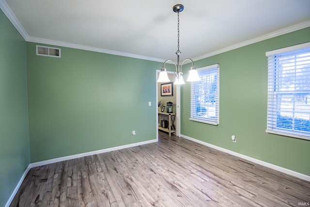 unfurnished dining area featuring crown molding, a notable chandelier, and light wood-type flooring