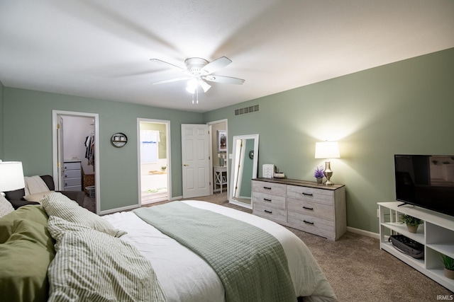 carpeted bedroom featuring ceiling fan, a walk in closet, ensuite bathroom, and a closet