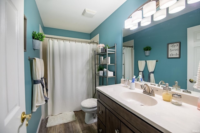 bathroom with wood-type flooring, a shower with shower curtain, vanity, and toilet