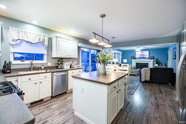 kitchen featuring a kitchen island, pendant lighting, dishwasher, sink, and white cabinets