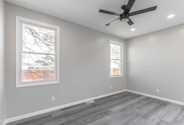 unfurnished room with ceiling fan, plenty of natural light, and dark hardwood / wood-style floors