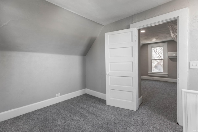 bonus room with vaulted ceiling and dark carpet