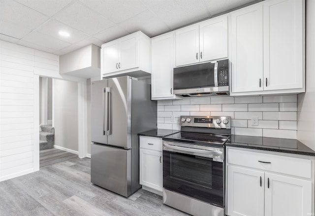 kitchen featuring stainless steel appliances, white cabinetry, a drop ceiling, and light hardwood / wood-style floors