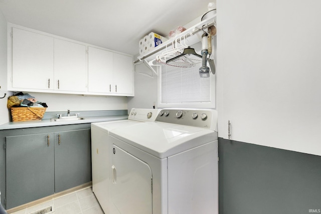 laundry room with cabinets, washing machine and dryer, and sink