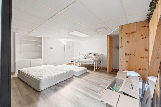 bedroom featuring hardwood / wood-style flooring and a drop ceiling