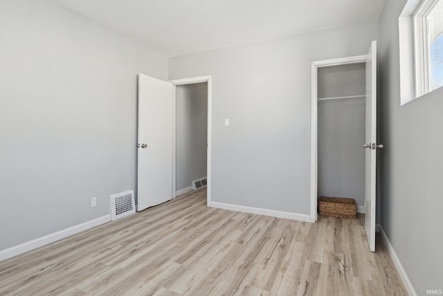 unfurnished bedroom featuring a closet and light wood-type flooring