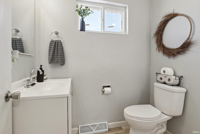 bathroom featuring vanity, toilet, and hardwood / wood-style floors