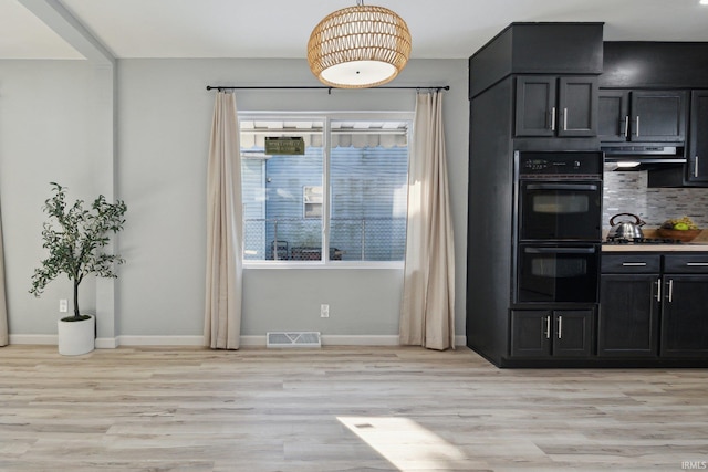 kitchen with backsplash, light hardwood / wood-style floors, and black appliances